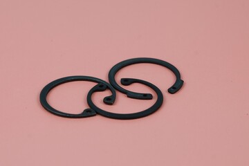 Close up three circlip or ring retaining isolated on brown background. Industrial concept.