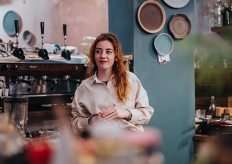 Cozy interior of a coffee shop, featuring a barista near the counter surrounded by artistic decor....