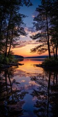 Fototapeta premium Serene Lakeside Sunrise: A tranquil sunrise over a tranquil lake, framed by the silhouettes of majestic trees, reflecting the vibrant colors of dawn in perfect symmetry.