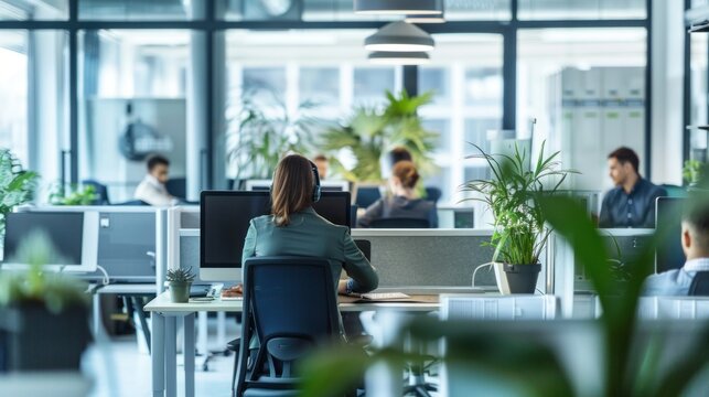 Modern open-plan office with employees working at computers stock photo --ar 16:9 --raw --v 6 Job ID: 93e1b0b6-1355-4267-b791-25c529bec4c0 - Powered by Adobe