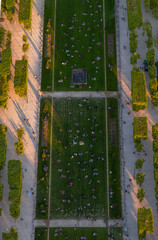 An aerial view from above of people relaxing and picnicking on the green lawns of the Champ de Mars in Paris, France, at sunset, taking advantage of the last rays of the sun.