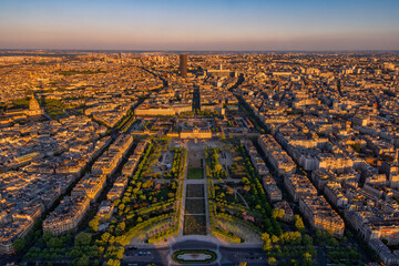 Aerial panoramic view with the golden light beautifully illuminating the Champ de Mars with people picnicking and the École Militaire de Paris at sunset.