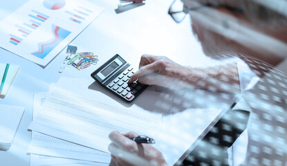 Senior businessman using a calculator, hard light; light effect