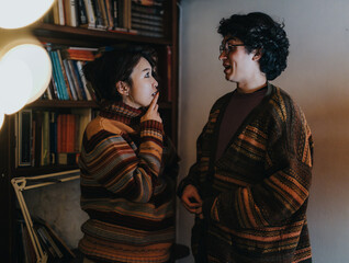 A warmly lit room with two casually dressed individuals sharing a lively and engaging conversation....