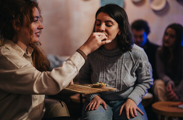 A group of friends spends quality time together sharing food and enjoying conversation in a...