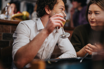 A candid moment of two friends sharing drinks and engaging in friendly conversation at a bar.