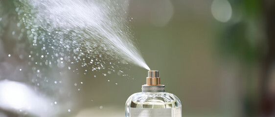 A fine mist of perfume sprays gracefully into the air, releasing a delicate fragrance that evokes elegance and freshness.