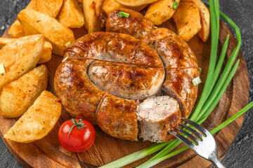 Grilled homemade sausage served with golden potato wedges, fresh tomato, and green onions on a rustic wooden board creates a hearty and flavorful meal
