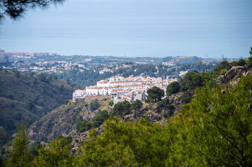 Scenic view of surrounding mountains and picturesque village from a hiking trail along an old...