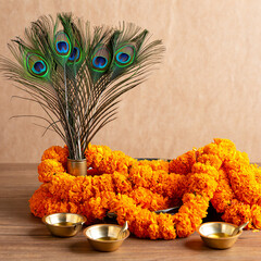 Peacock feathers and marigold garland with oil lamps