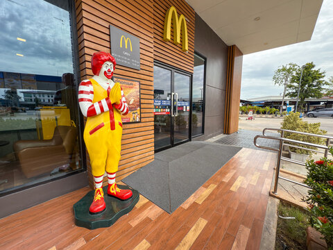 Bangkok, Thailand - June 20, 2025: Ronald McDonald statue greets wai customers outside McDonalds restaurant entrance in Thailand