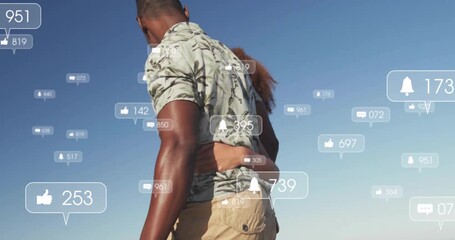 Couple walking along beach starting floating social media icons signaling online interest - Powered by Adobe