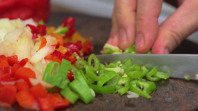 Chop chilies peppers, onions, and bell peppers to cook sofrito. Homemade food daily life