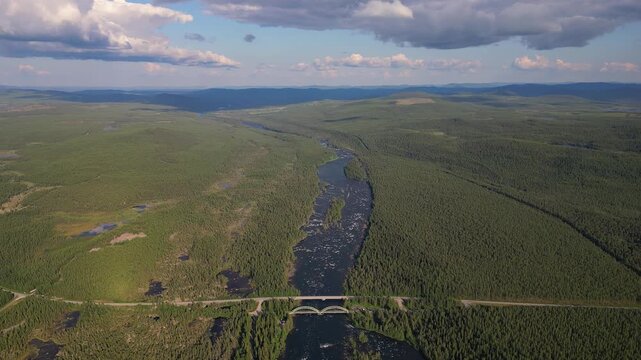 Aerial view of the E45 road and rail bridges stretching over the Kalixalven River in Lapland, Sweden