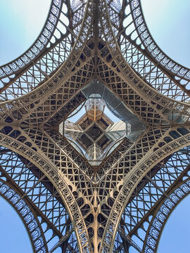 Looking up through middle of Eiffel Tower from underneath in Paris.