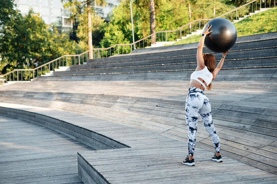 Woman Exercising Outdoors with Fitness Ball