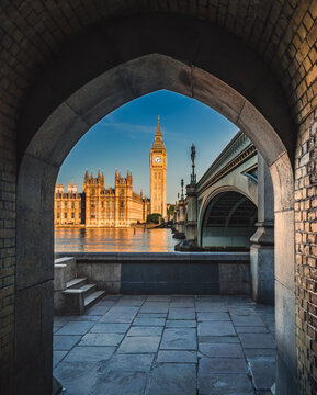 Big Ben and Palace of Westminster framed under arch in London, UK.