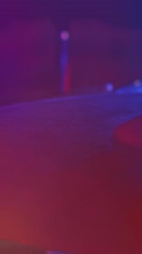 Video of hands of drummer playing drum kit, cymbal in foreground, red and blue light