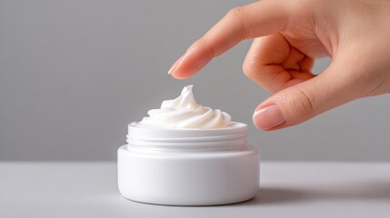A close-up shot showcases a hand touching a jar of cream, illustrating skincare. The cream appears smooth and creamy