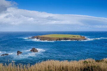 Small Volcanic Island Surrounded By Deep Blue Atlantic Ocean Waters in Ponta Topo, Sao Jorge, With Dramatic Cloudy Sky. Remote Islet, Coastal Cliffs, Maritime Landscape, Seascape Photography