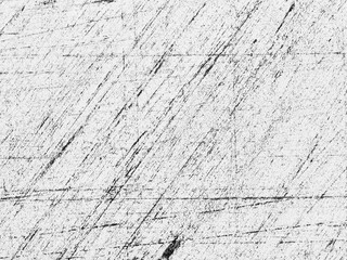 Abstract patterns on a textured surface captured in black and white showing scratches and lines in varying intensity