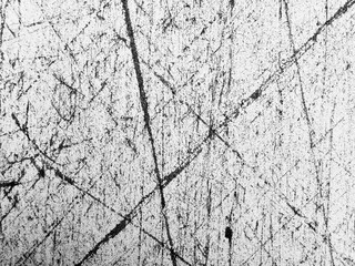 Scratched surface reveals intricate patterns and textures in monochrome tones at an urban location