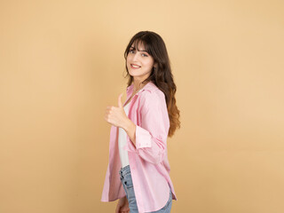 Side view portrait of young caucasian 20s woman showing thumb up like gesture smiling happy...