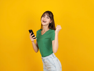 Side view portrait of young caucasian 20s fun woman hold in hand use mobile phone doing winner...