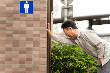 公衆トイレに入るミドル男性　ライフスタイルイメージ