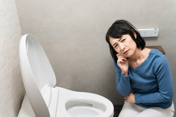 トイレのトラブルで困るミドル女性　ライフスタイルイメージ