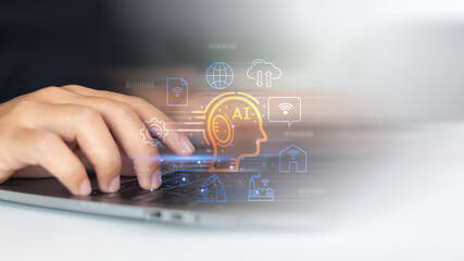 Close-up hand typing on laptop with glowing AI icon and smart tech symbols. Concept of artificial intelligence, machine learning, IoT, and digital transformation.