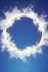 Obraz premium a luminous golden ring encircled by soft white clouds, set against a vibrant deep blue sky, creating a captivating and celestial frame