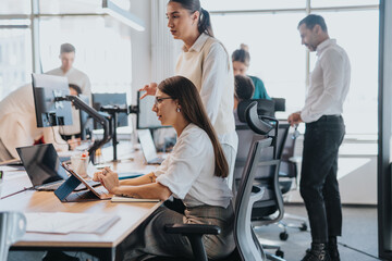 A multicultural group of business people working collaboratively in an open office space. The image...