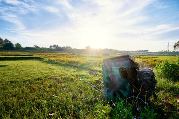 Rustic Farm Equipment Amid a Sunlit Landscaped Countryside During Morning Light