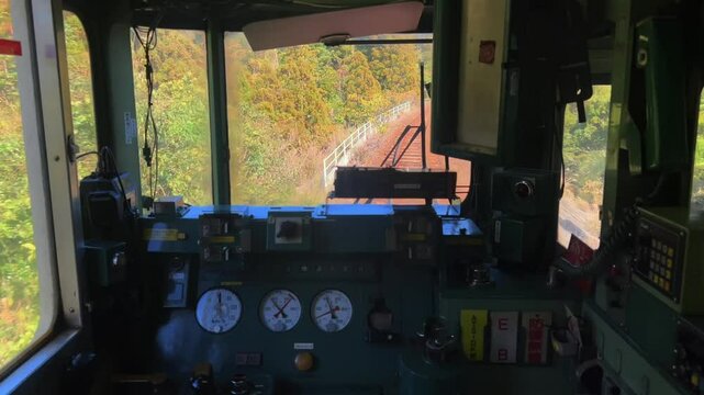 From the perspective of an old train cab: As the train moves forward, autumn colors are rich outside the window, and the railway tracks wind into the distance.