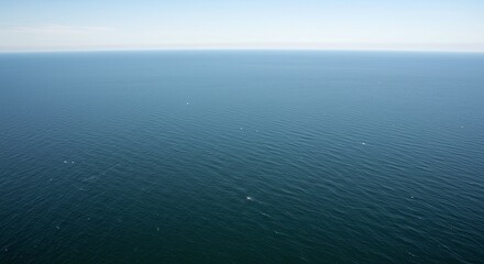 Obraz premium Aerial View of Calm Blue Ocean with Small Boats in Open Sea During Day