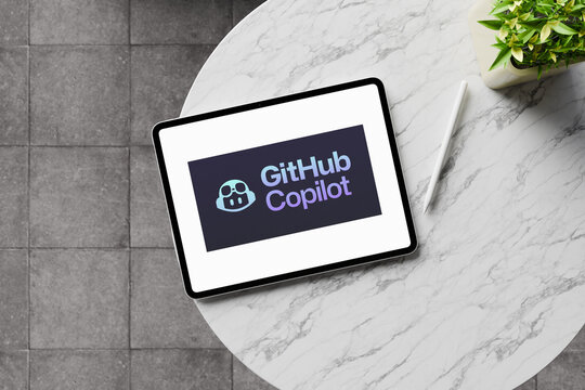 Github copilot logo displayed on tablet screen on marble table