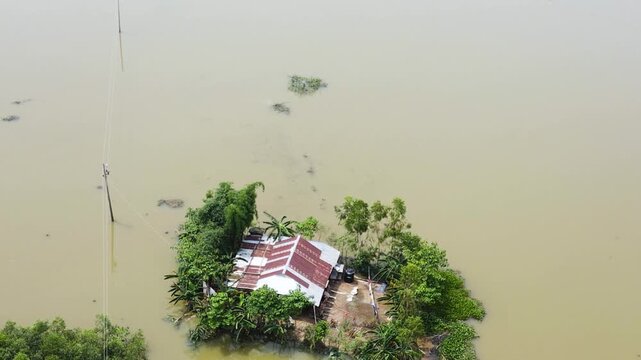 A Rural House is Surrounded by Floodwaters in the Haor Area, Reflecting the Recurring Flood Challenges in Sylhet, Bangladesh, South Asia - Aerial Ascend Shot