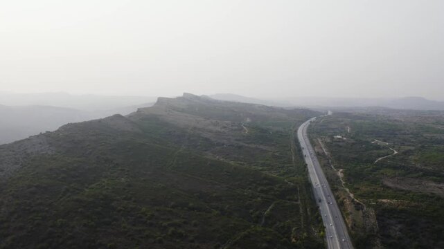Aerial view of M2 motorway winding past the rocky summer hills of Kallar Kahar and Chakwal. Pakistan