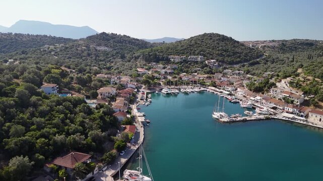 Flight toward quiet ocean waterfront of Vathy Greece, boats moored