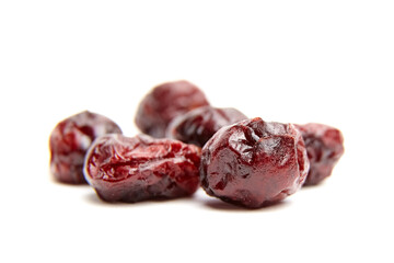 Dried red cranberries arranged on a white background, showcasing their wrinkled texture and rich color, ideal for healthy snacks, baking, or culinary uses