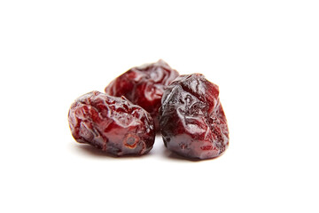 Dried fruit pieces, deep red in color, showcasing a wrinkled texture, arranged on a clean white...