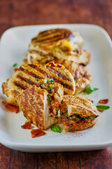 grilled pork chops stuffed with gouda cheese, bacon, spinach and sun dried tomatoes, front piece sliced open