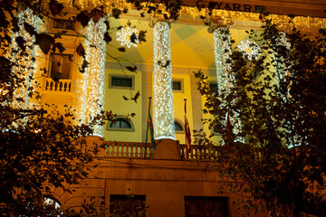 Brightly lit columns of a historic building in Pamplona Navarra during a festive evening...