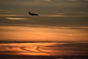 Jet plane landing at sunset