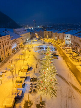 Aerial view of a snow-covered square, dominated by a brightly lit Christmas tree, glows warmly against the cool, dark twilight, Bansk&Atilde;&iexcl; Bystrica, Banskobystrick&Atilde;&frac12; kraj, Slovakia.