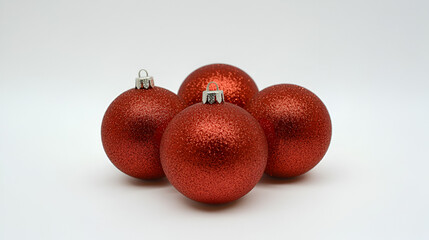 Four red Christmas ornaments with glittery texture, arranged on a white background.