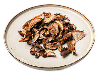 Dried organic mushrooms mix with chanterelles and porcini on white porcelain plate isolated on transparent background