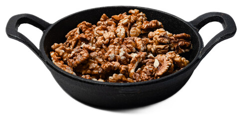 Shelled raw walnut kernels in a black cast iron skillet with transparent background for healthy...