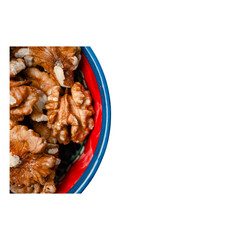 Raw organic shelled walnut kernels in a colorful ceramic bowl, closeup, highlighting their rich texture and natural brown hues, perfect for healthy snacking and plantbased nutrition